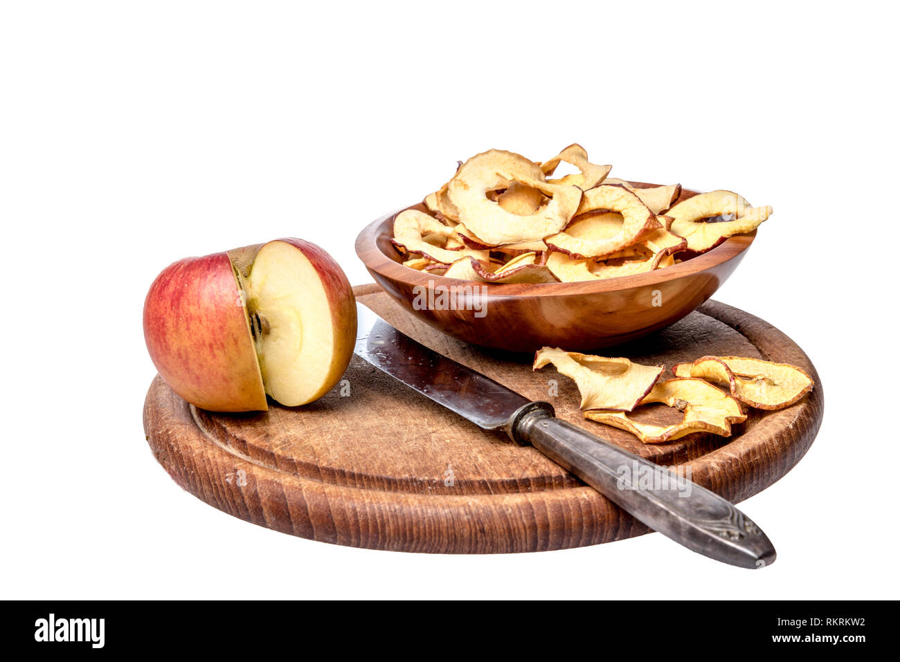 Dried apple rings lie on a board with a freshly cut apple Stock Photo