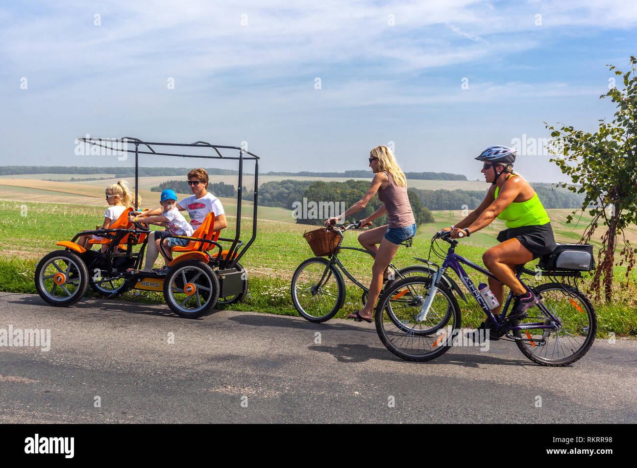 Summer vacation, Family bike ride, women, children riding a bike on the country road South Moravia, Czech Republic cycling diverse Stock Photo
