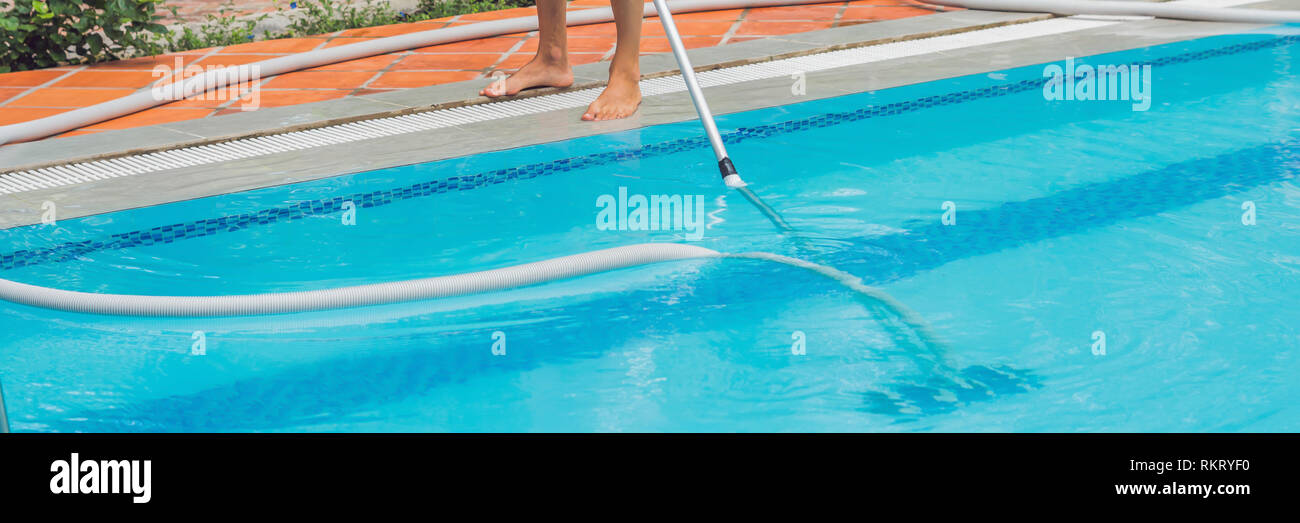 Cleaner of the swimming pool . Man in a blue shirt with cleaning