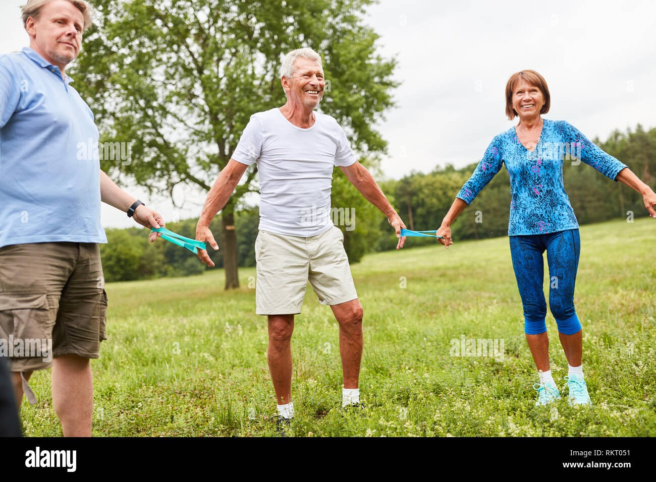 Group of active seniors with stretch band in circle at the physiotherapy Stock Photo