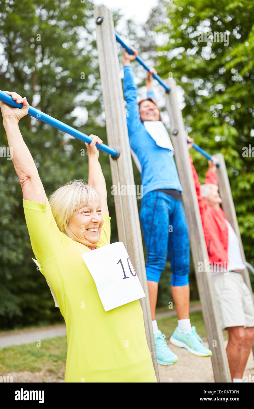 Group of seniors exercises fitness on the trim you course in nature Stock Photo