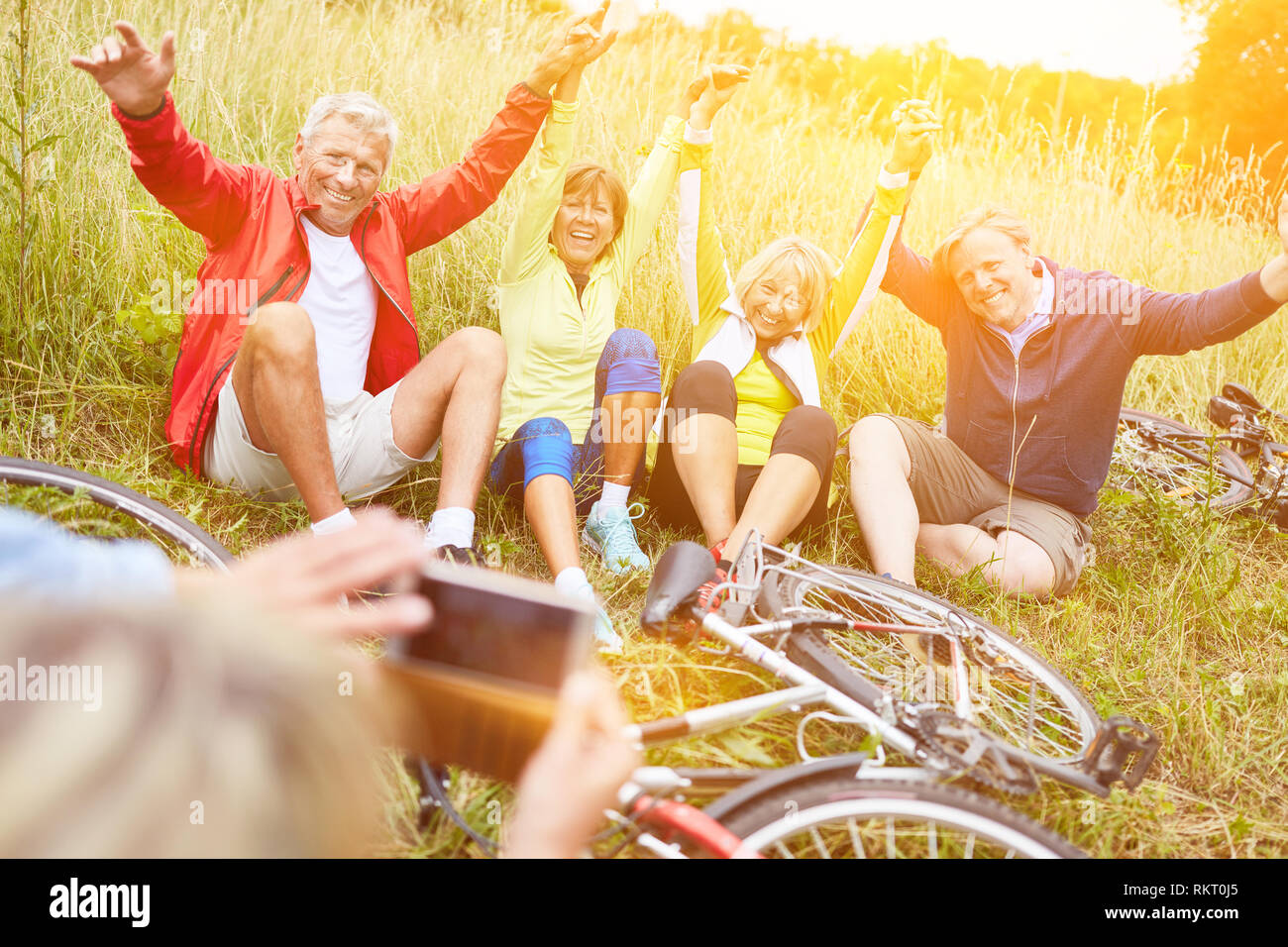 Laughing seniors on bike ride in nature take photo with smartphone Stock Photo