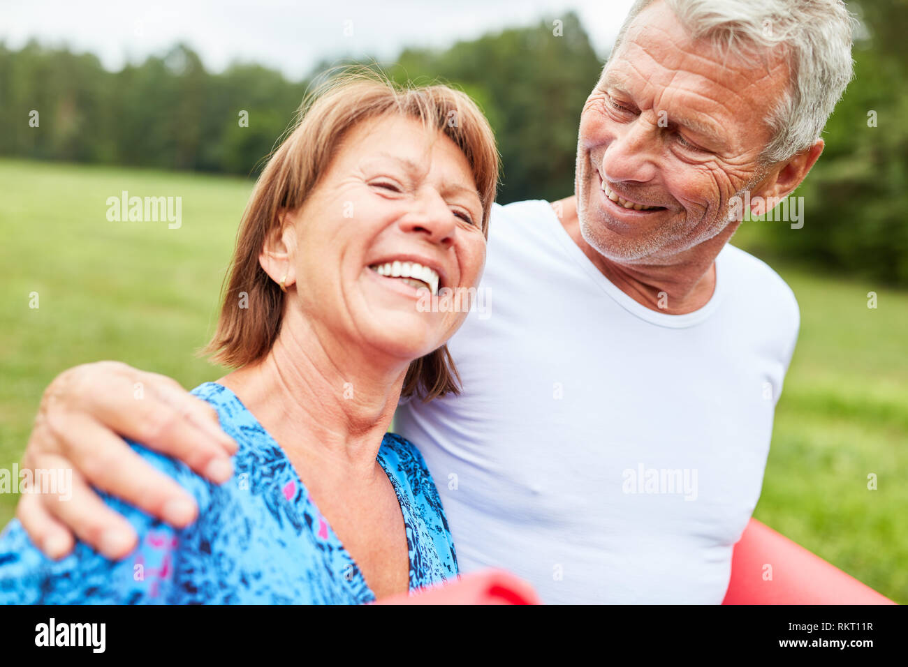 Happy seniors couple walking in the park in summer Stock Photo