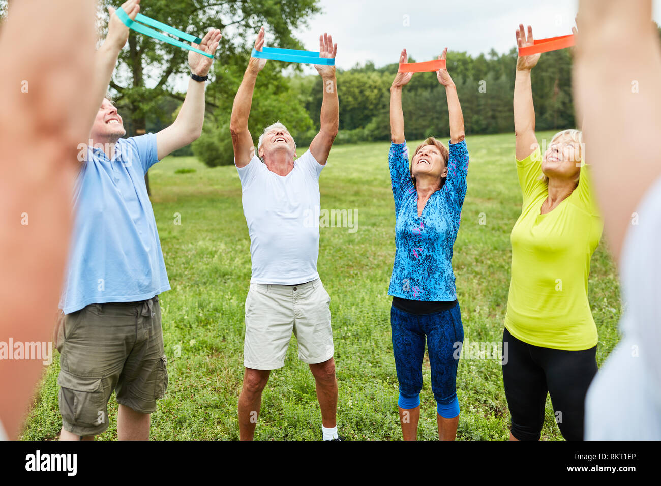 Seniors do gymnastics with the stretch band as physiotherapy in the rehab Stock Photo