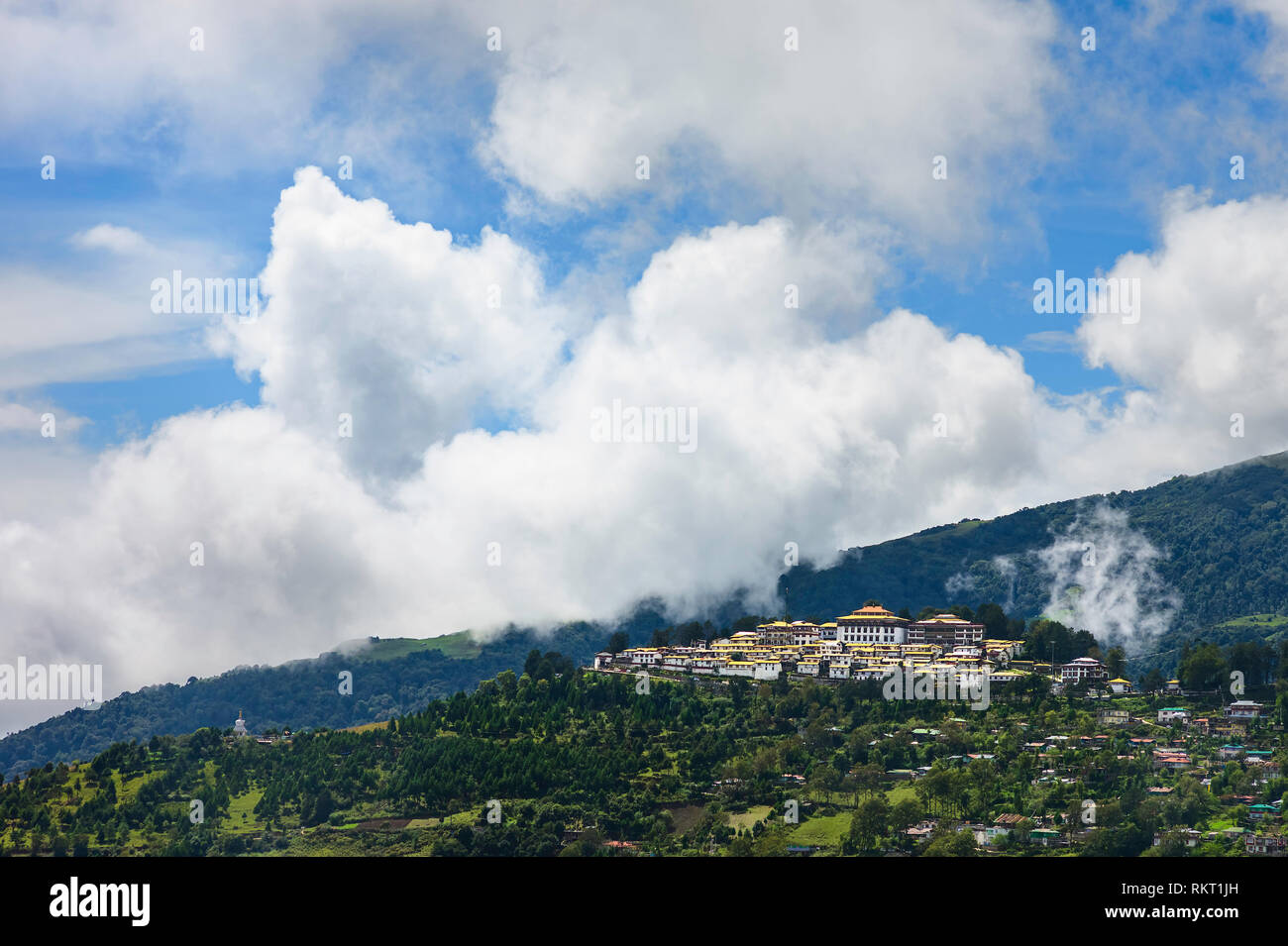 The ancient Buddhist monastery set against the Himalayas with heavy clouds and surrounded by the town at Tawang, Arunachal Pradesh, India. Stock Photo