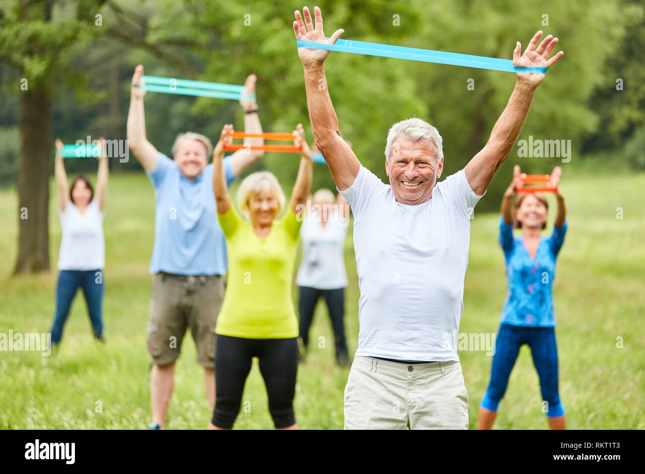 Seniors exercise fitness with stretch band in physiotherapy in rehab course Stock Photo