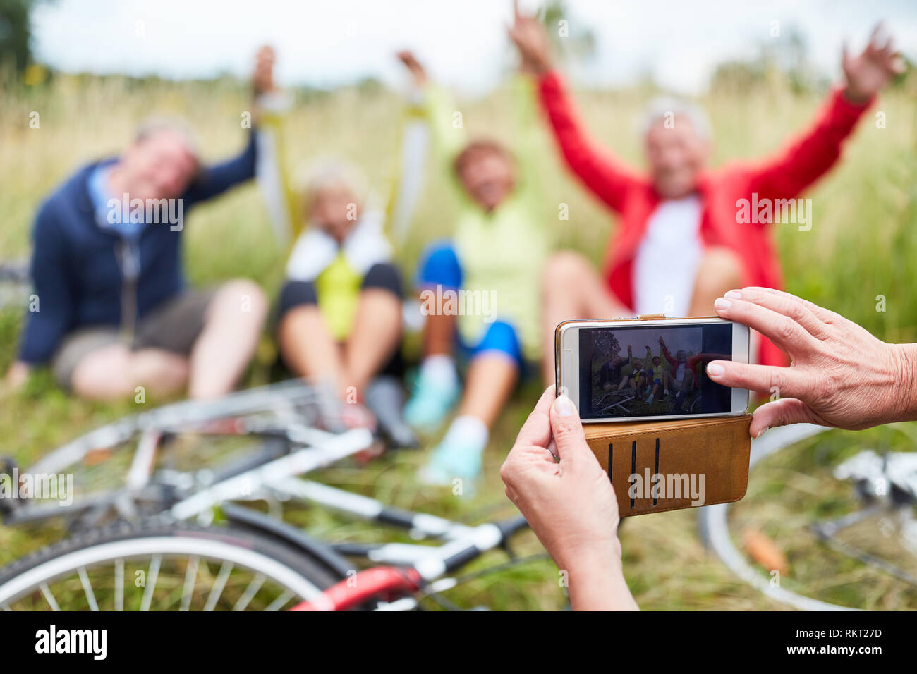 Person takes photos with the smartphone from the senior group on bike ride Stock Photo