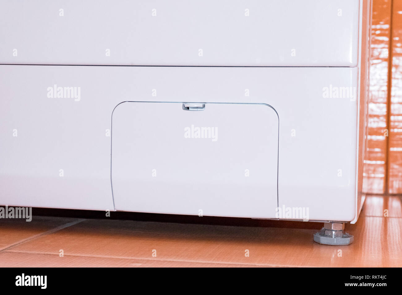 Closed compartment for washing machine filter. View from below. Orange