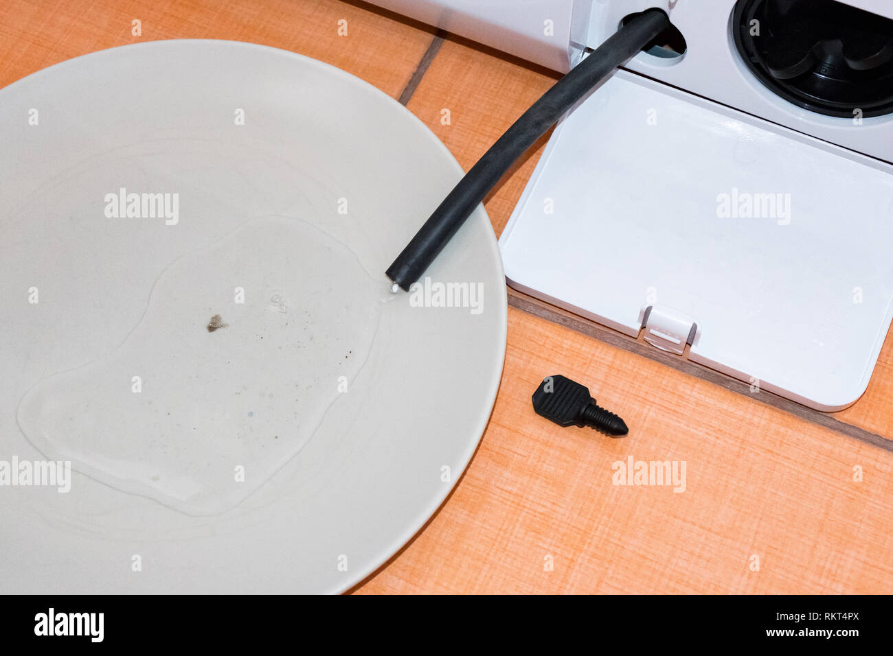 Cleaning the washing machine filter. Draining water from a black tube. Washmachine detail Stock Photo