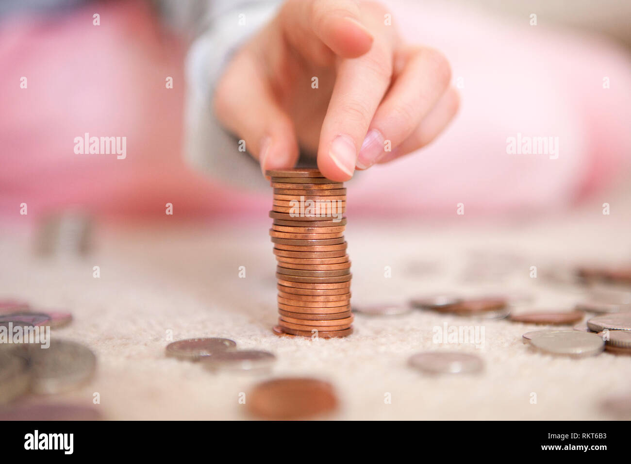 Child stacking coins of pocket money Stock Photo