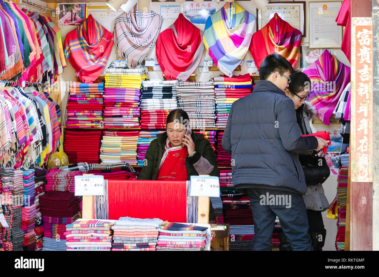 People shopping in a textile shop in Lijiang old town, Yunnan, China Stock Photo