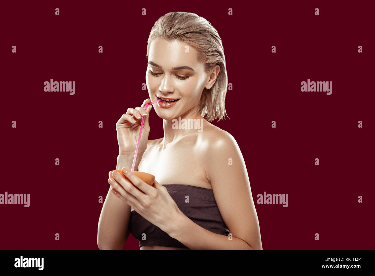 Blonde-haired slim model sipping some grapefruit juice Stock Photo