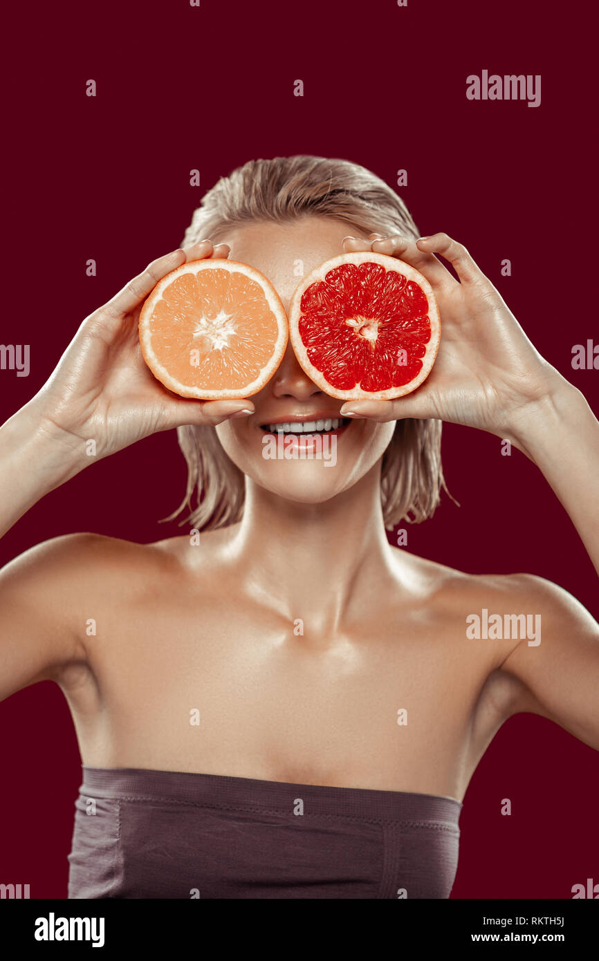 Model with short bob cut posing with orange and grapefruit Stock Photo