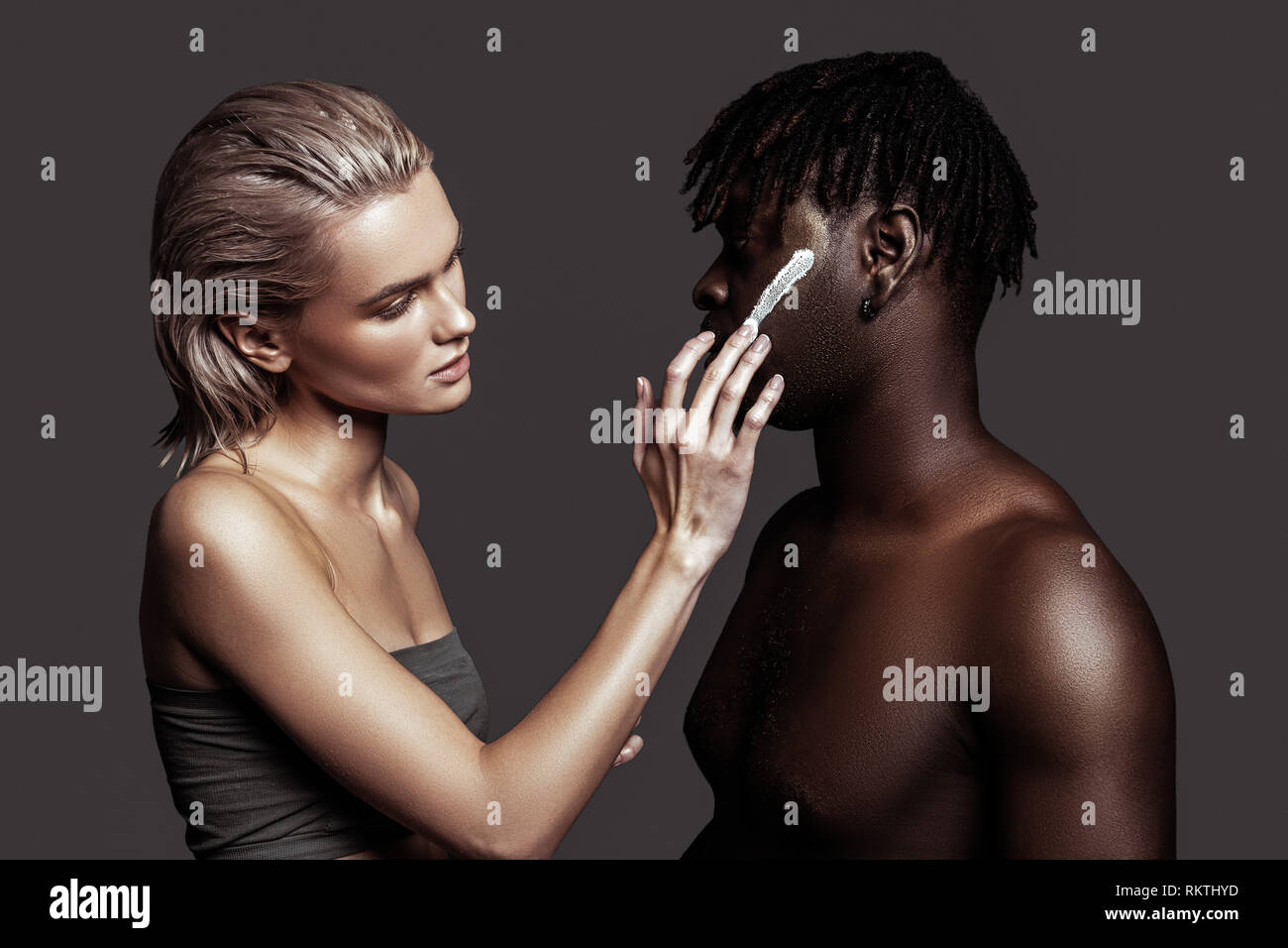 Two models using face cream while promoting cosmetics Stock Photo