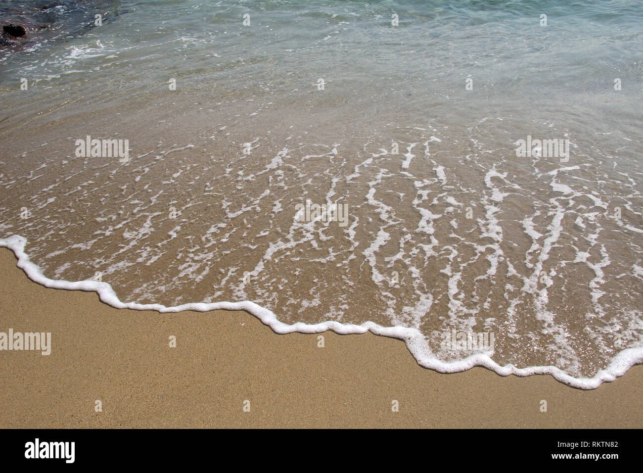 White foamy wave popping out on a beach Stock Photo - Alamy