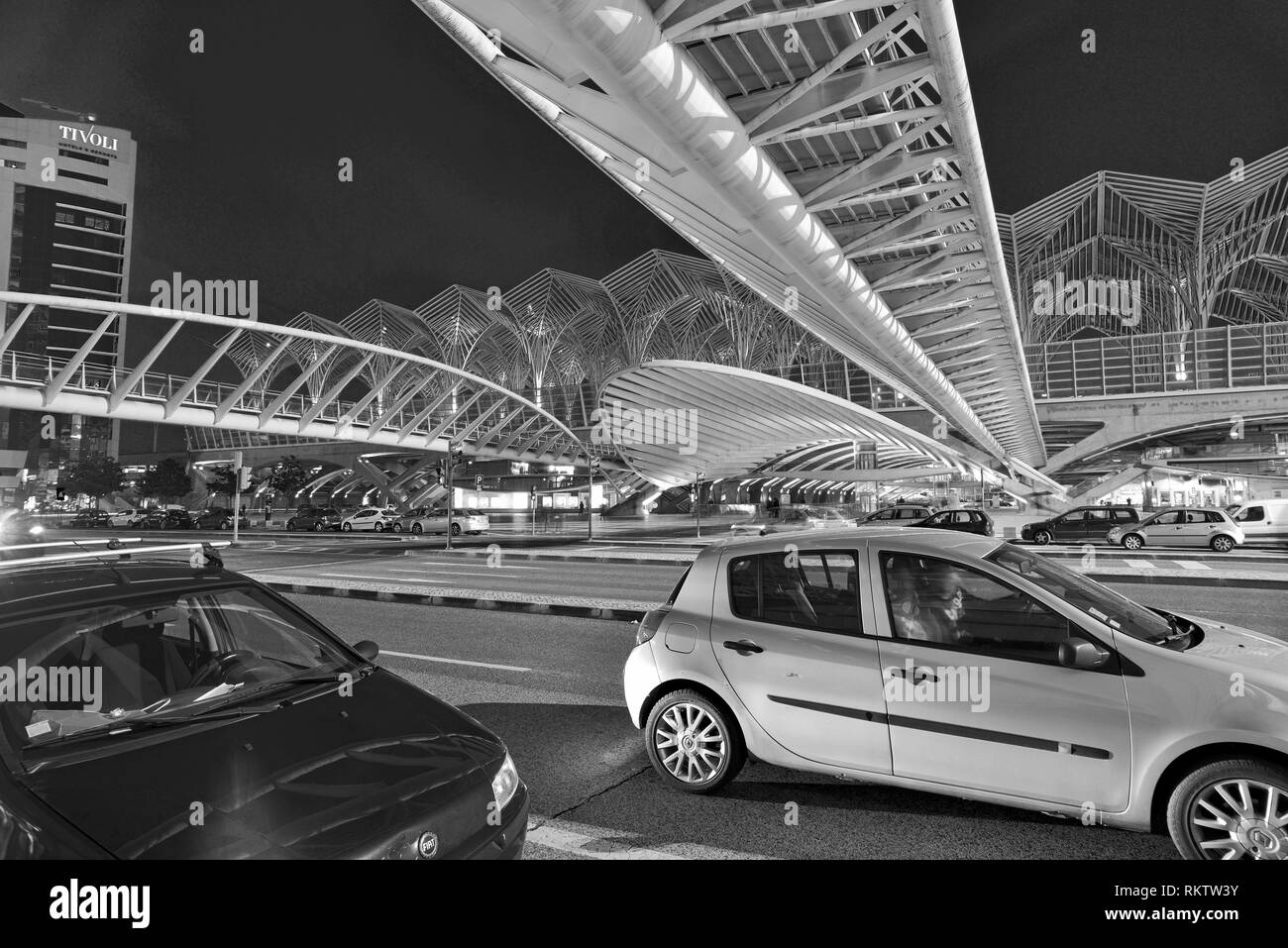 Evening traffic in large road with futuristic steel roof and bridge Stock Photo