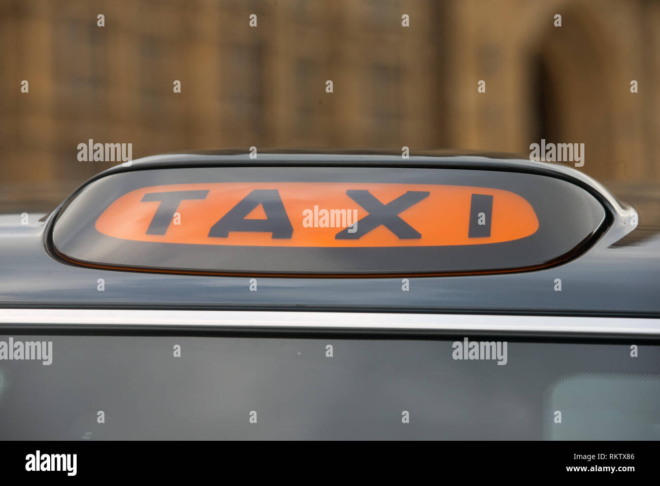 A modern Taxi light on top of an electric black cab. Stock Photo