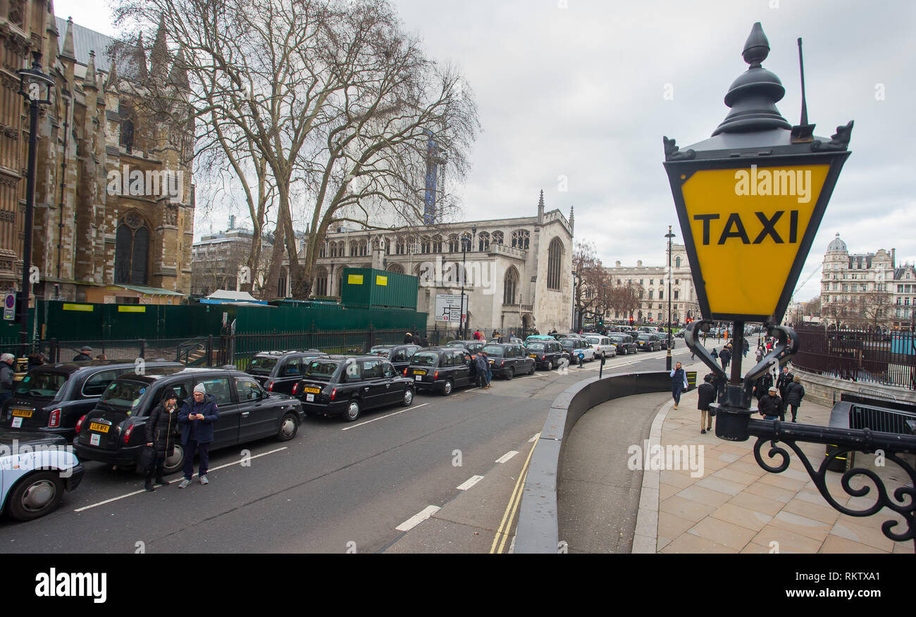 Protesting black cab's are parked along Abingdon Street beside the taxi entrance lamp at the Houses of Parliament. Stock Photo