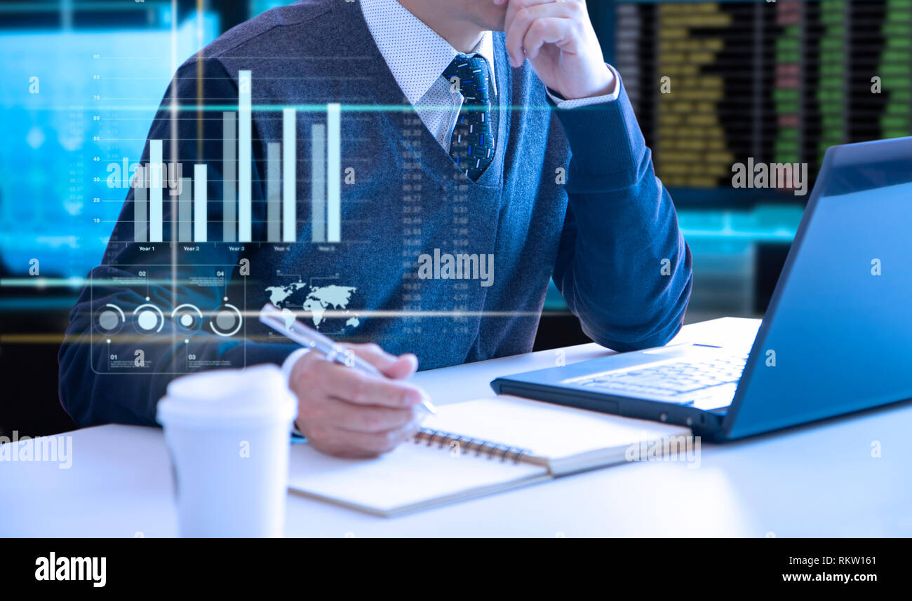 Businessman looking into a laptop notebook computer screen reviewing a return on investment or business performance with colourful graphs. Stock Photo