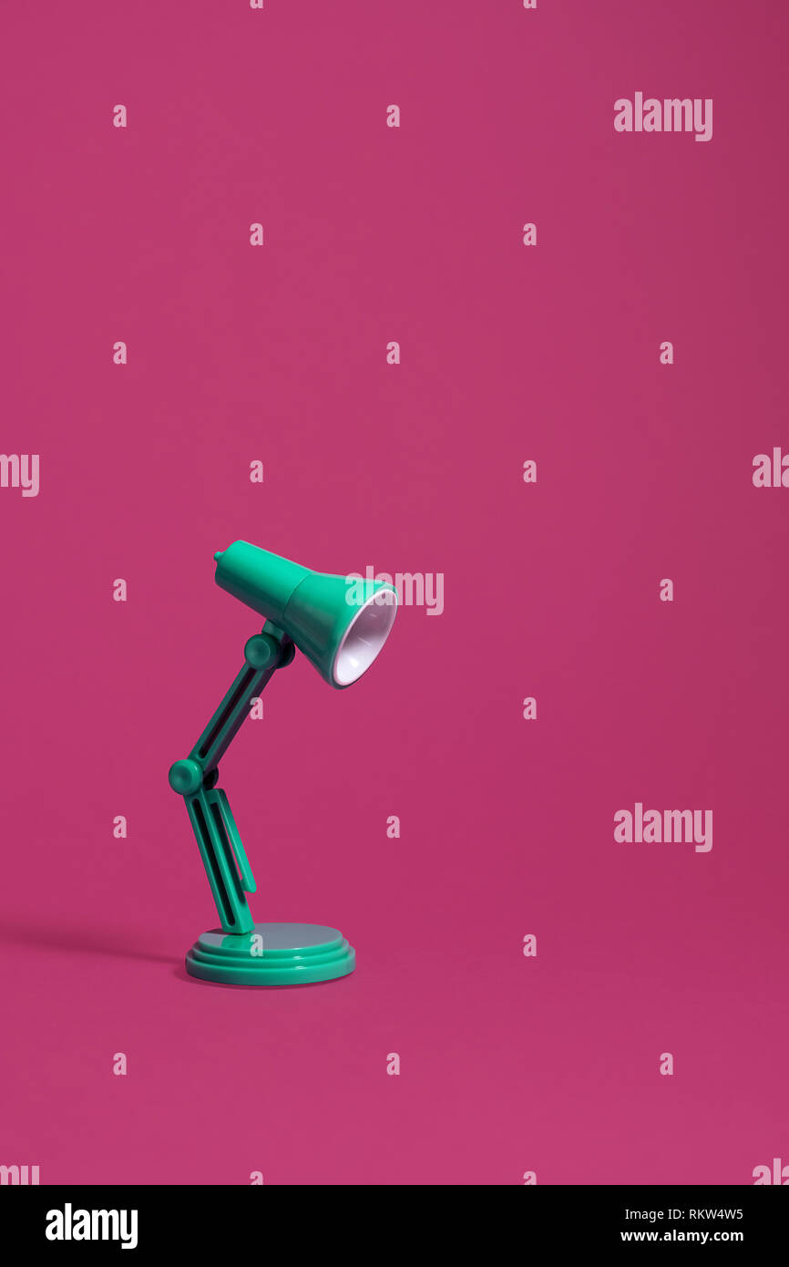 Vintage green desk lamp on a pink background, turned off.  Vertical image with copy space at the top of the image Stock Photo