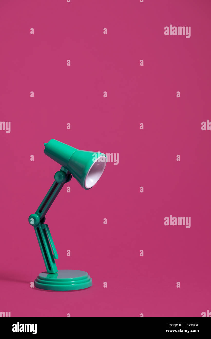 Vintage green desk lamp on a pink background, turned off.  Vertical image with copy space at the top of the image Stock Photo