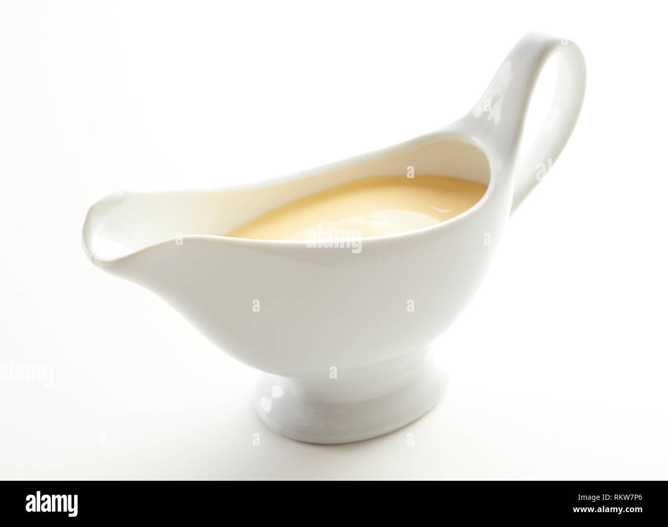 Sauce boat filled with creamy Hollandaise sauce made from melted butter