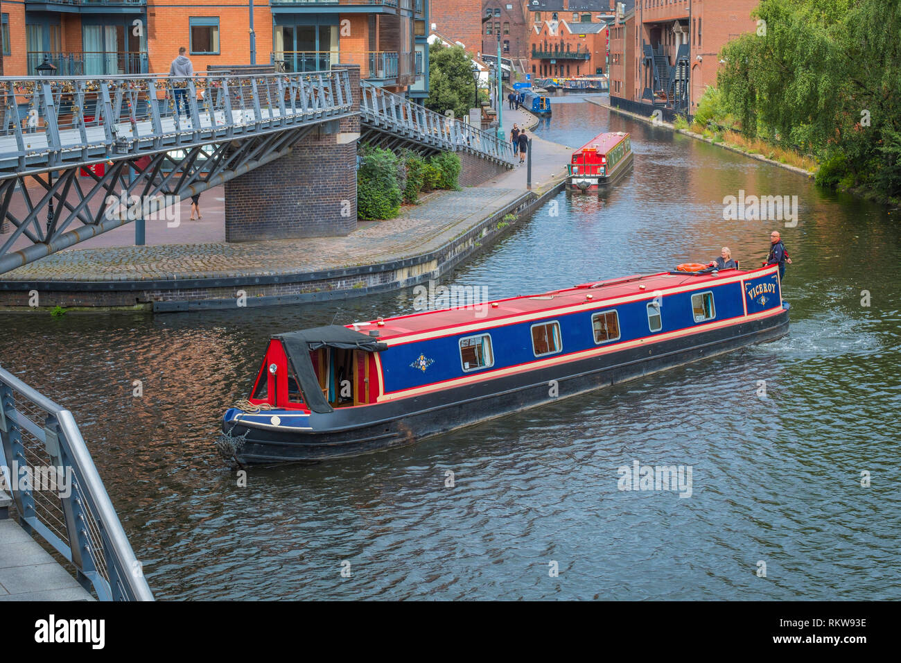 A narrowboat negotiates the corner on the Birmingham Canal Old Main Line at Salvage Turn Bridge by The Mailbox. Stock Photo