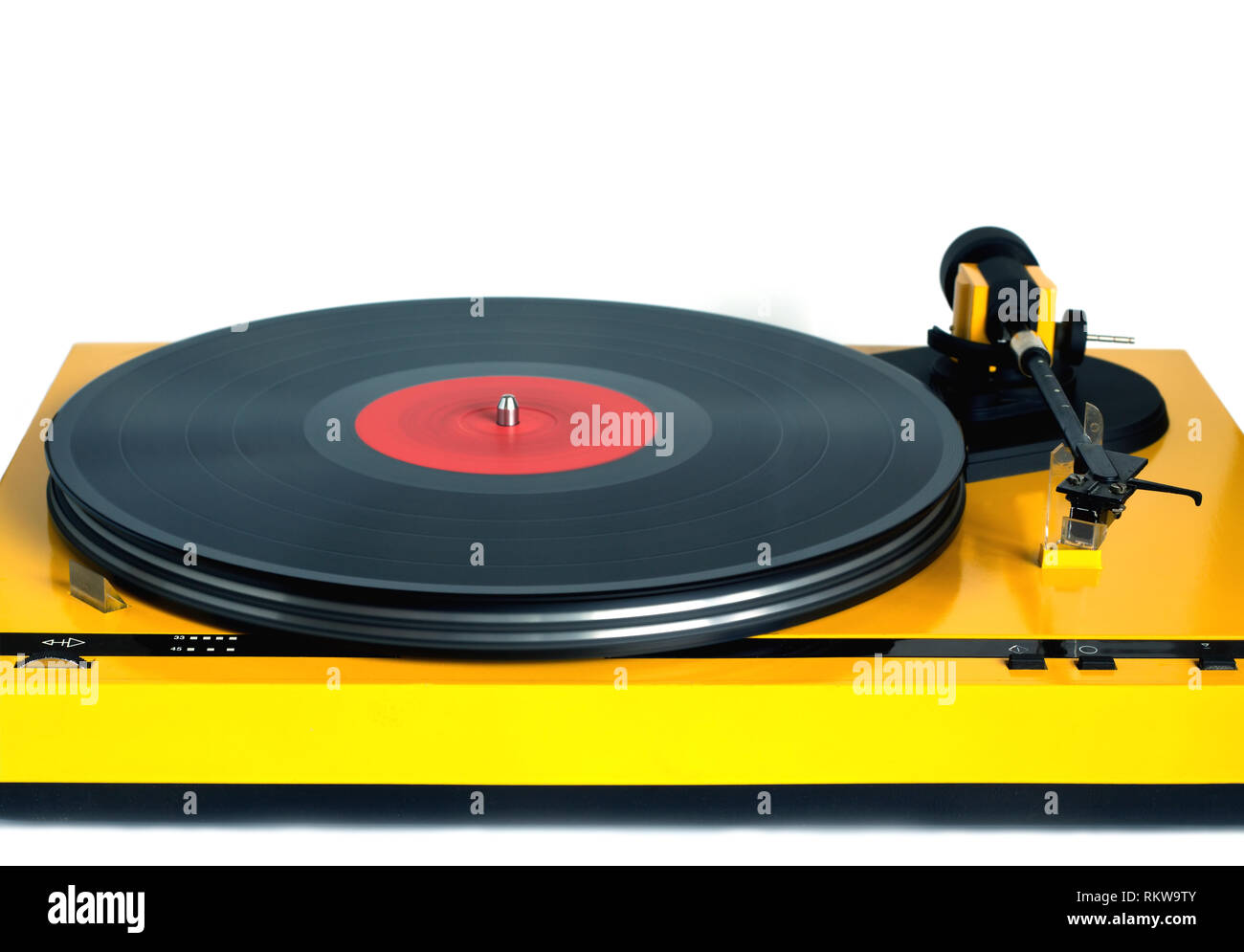 Funny turntable in yellow case with rotation vinyl record with red label isolated on white background. Horizontal photo front view closeup Stock Photo