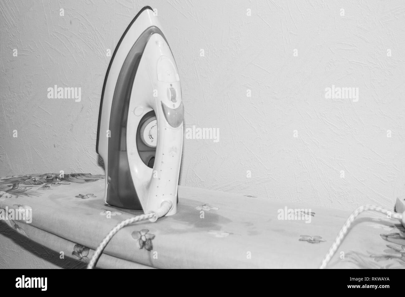 Black and white photo, vertical iron on Ironing Board Stock Photo Alamy