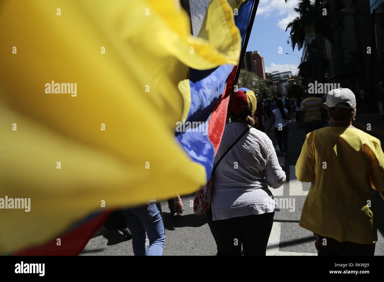 Caracas, Venezuela. 12th Feb, 2019. Women march with Venezuelan flags and caps at a rally of government opponents. On the occasion of Youth Day, demonstrators called on the armed forces to let humanitarian aid into the country for the suffering population. Since last week, ten trucks with about 100 tons of relief supplies have been waiting in the Colombian border town of Cucuta for permission to pass. Credit: Rafael Hernandez/dpa/Alamy Live News Stock Photo