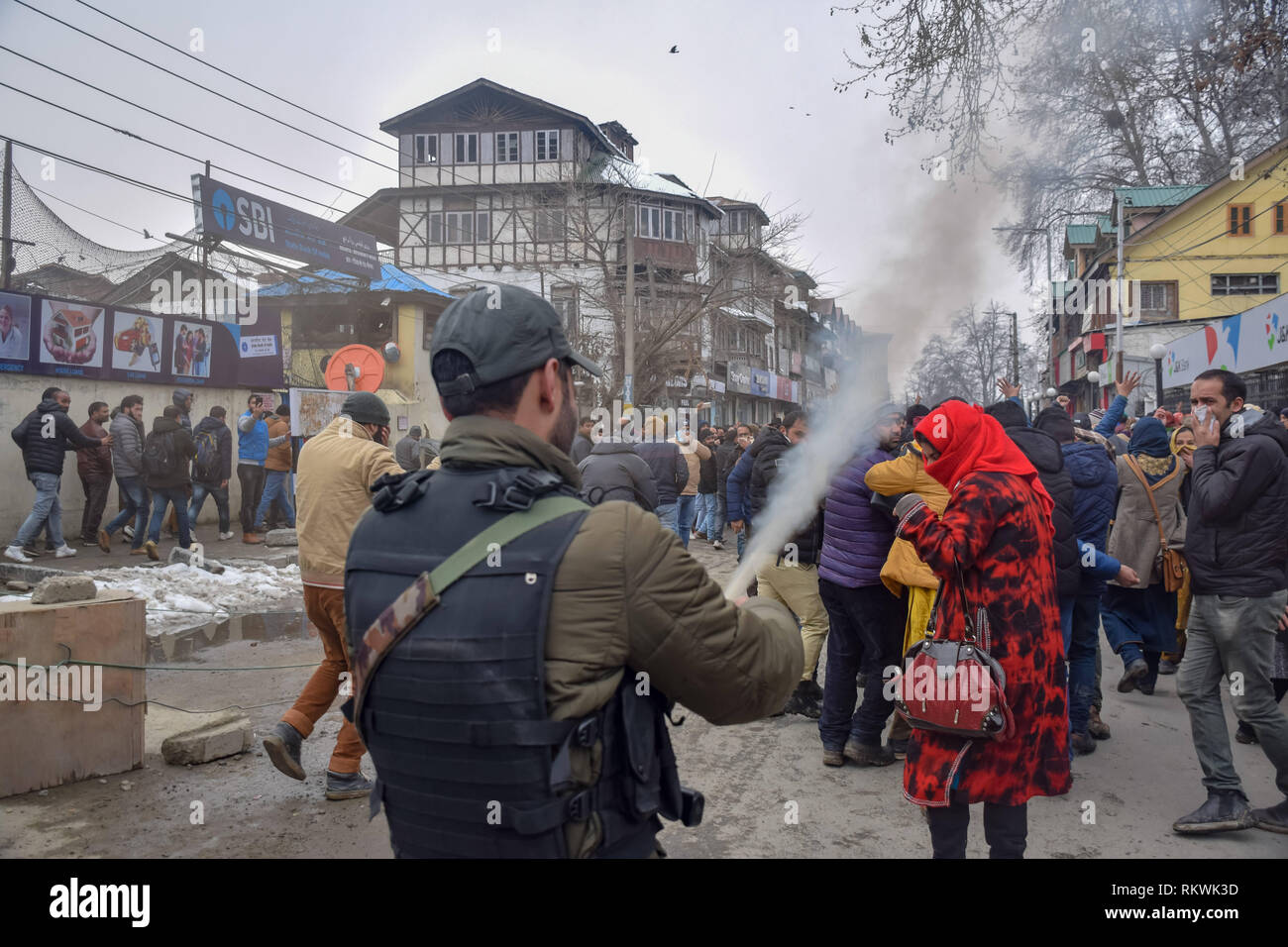 February 12, 2019 - Srinagar, Jammu & Kashmir - Jammu and Kashmir police member seen spraying pepper gas to disperse NHM employees during the protest in Srinagar.NHM (National Health Mission) employees on took out an anti-government protest march towards the Raj Bhavan in Srinagar. The employees who have been on a strike since the past thirty days are demanding regularization in a phased manner, equal pay for equal work and other social security benefits. Police used batons on the Protesters and many of them were detained during the protest. (Credit Image: © Idrees Abbas/SOPA Images vi Stock Photo