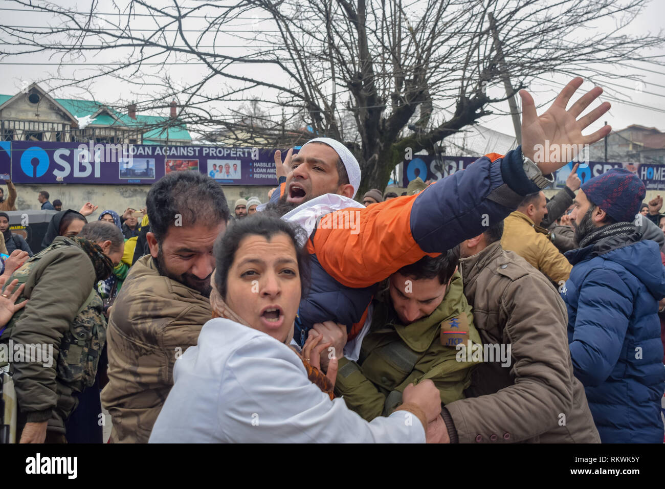 February 12, 2019 - Srinagar, Jammu & Kashmir - Indian police officers are seen detaining a member of NHM employees during an anti government protest in Srinagar.NHM (National Health Mission) employees on took out an anti-government protest march towards the Raj Bhavan in Srinagar. The employees who have been on a strike since the past thirty days are demanding regularization in a phased manner, equal pay for equal work and other social security benefits. Police used batons on the Protesters and many of them were detained during the protest. (Credit Image: © Idrees Abbas/SOPA Images vi Stock Photo