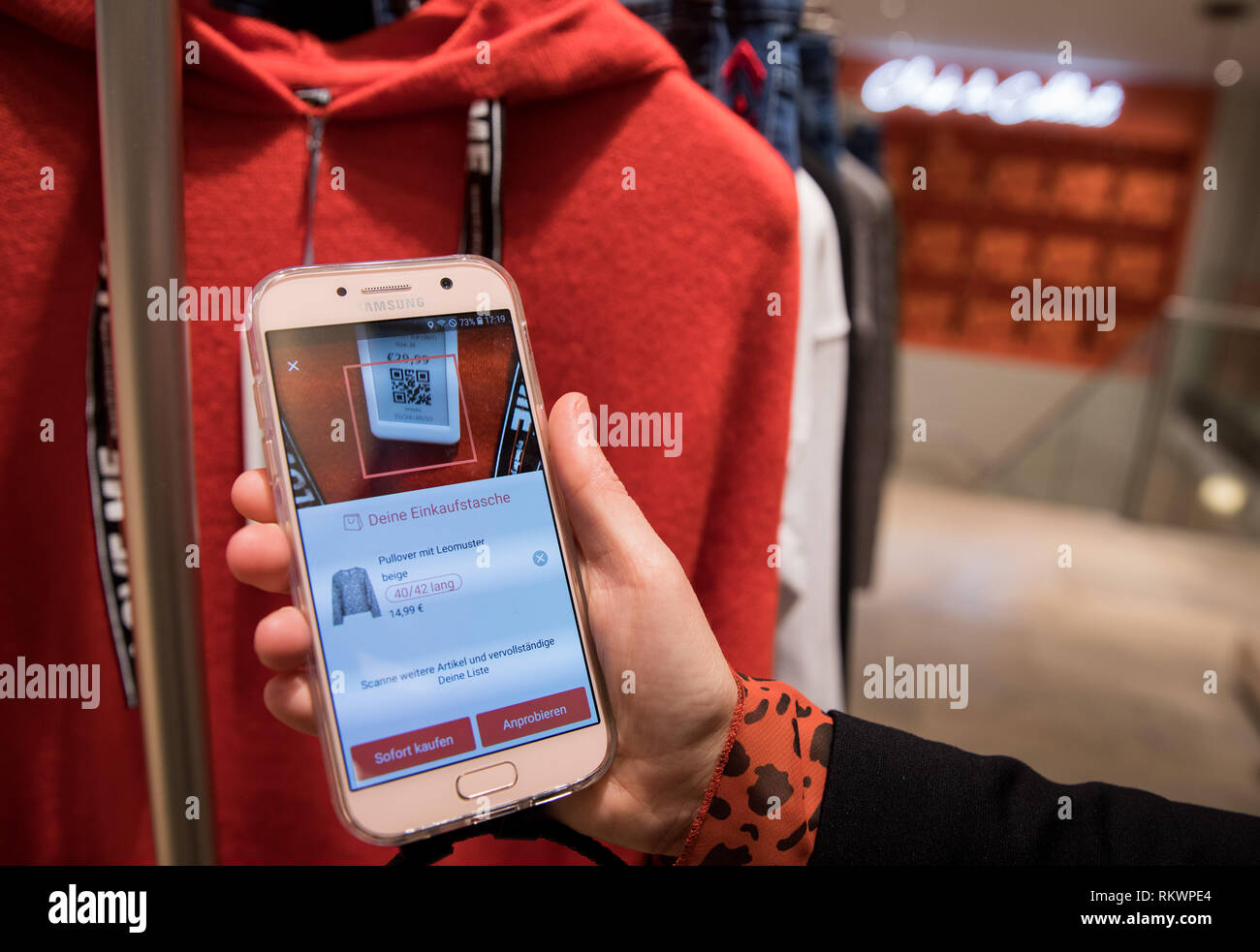 Hamburg, Germany. 04th Feb, 2019. An employee holds a mobile device with the bonprix App to the QR a garment at a press event in the new Bonprix Pilot store