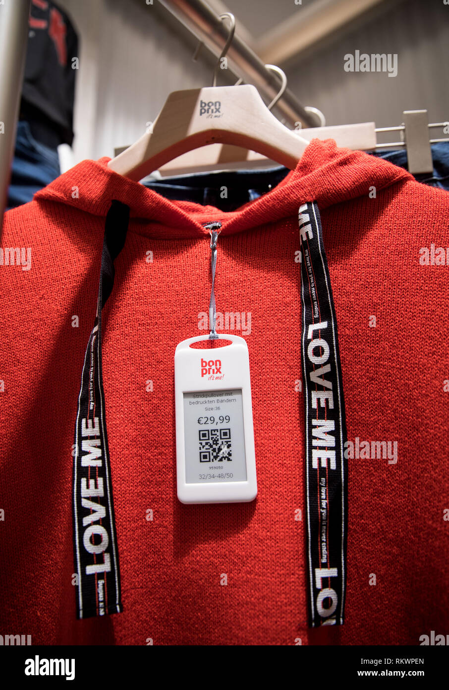 Hamburg, Germany. 04th Feb, 2019. A price tag with QR code hangs on a red  sweater in the new Bonprix Pilot store in downtown Hamburg. Under the motto  "fashion connect", Bonprix, an