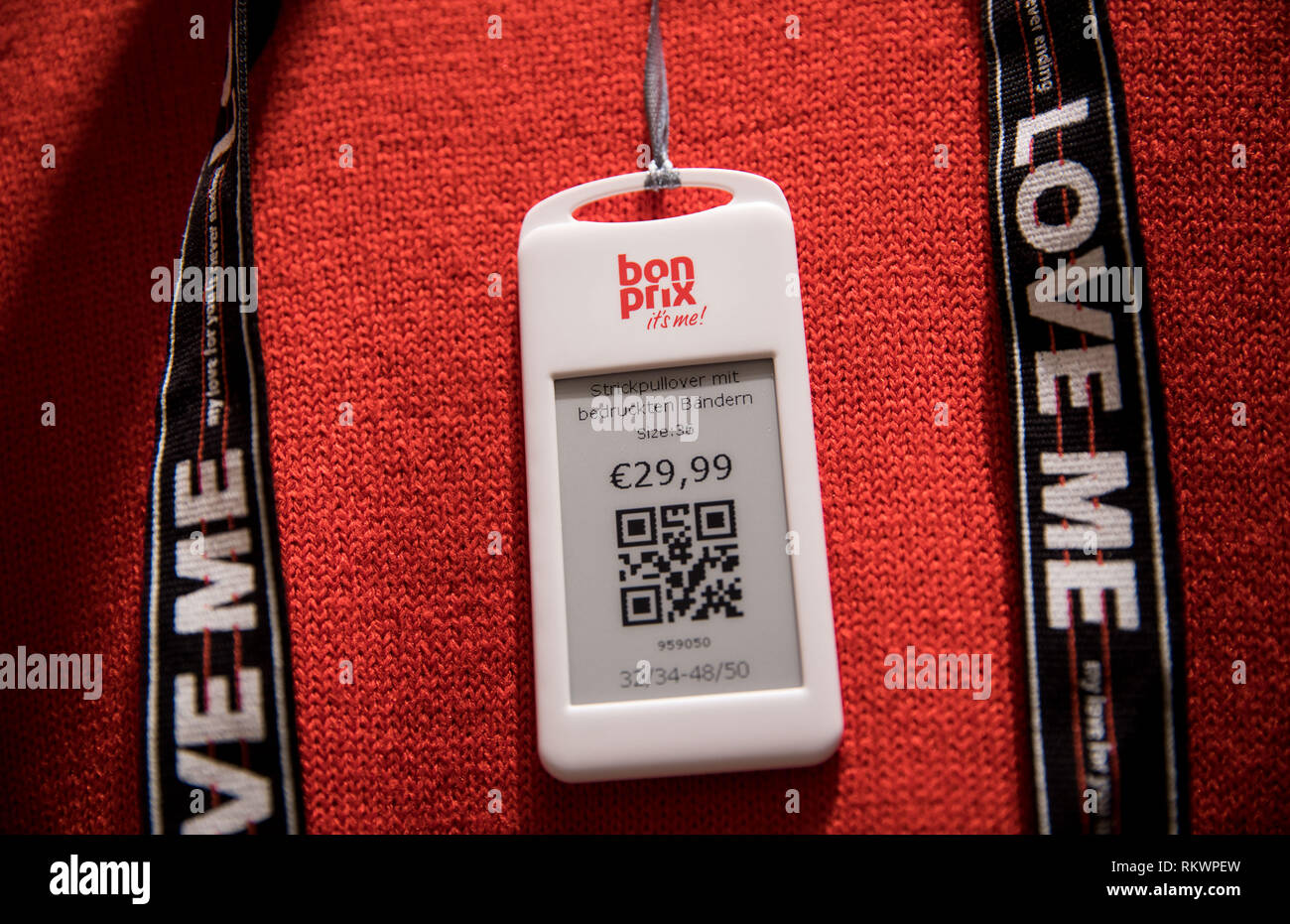 Hamburg, Germany. 04th Feb, 2019. A price tag with QR code hangs on a red  sweater in the new Bonprix Pilot store in downtown Hamburg. Under the motto  