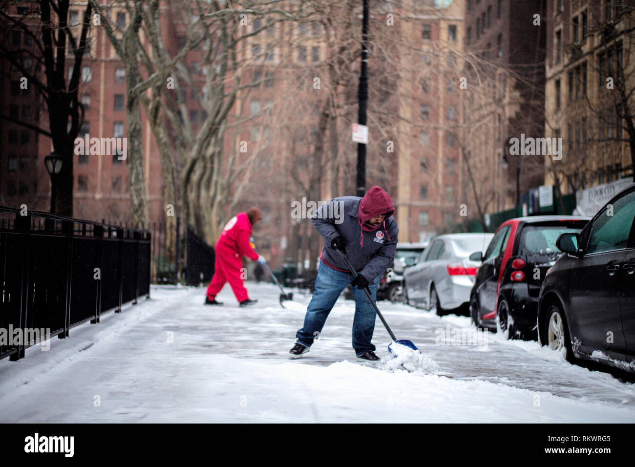 New York, USA. 12th Feb, 2019. People clear snow on the sidewalk in New York, the United States, on Feb. 12, 2019. Credit: Li Muzi/Xinhua/Alamy Live News Stock Photo