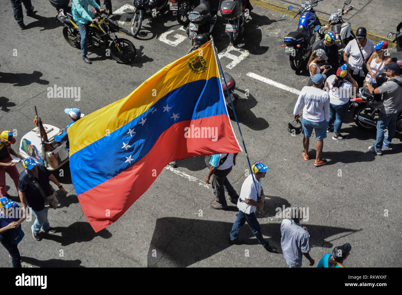 A man seen waving a huge flag of Venezuela during a protest to call for a change in the government. Opponents gather at a protest organised by the PSUV (United Socialist Party of Venezuela) after the call from interim president Juan Guaido, to show their support to him, while asking the army to allow more humanitarian aids into the country. Stock Photo