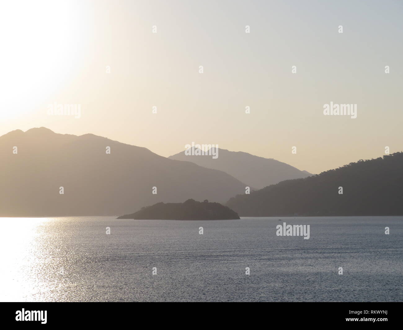 Sunrise on the sea coast. Dawn sky over the mountainous islands, picturesque seascape Stock Photo