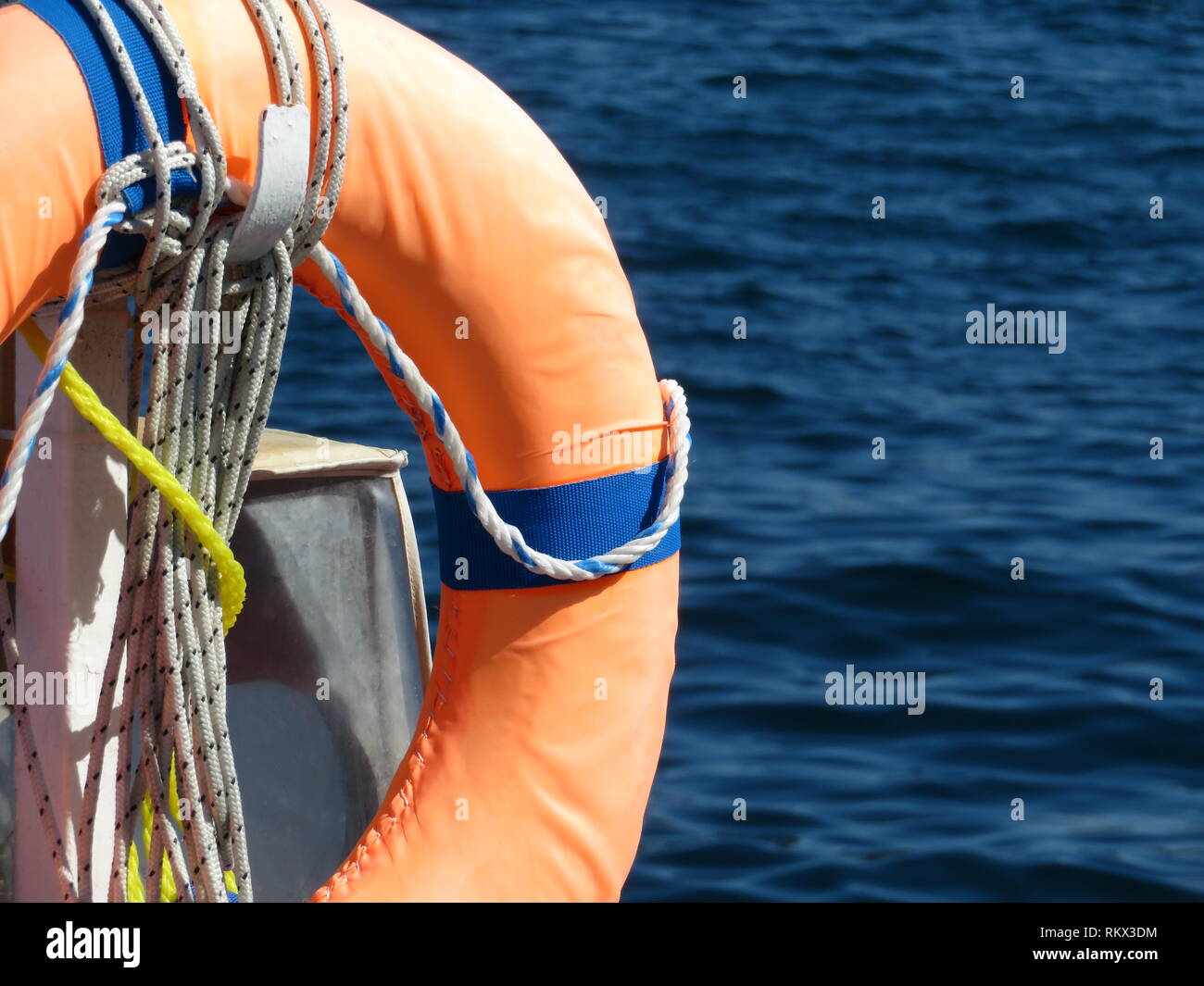 Orange life ring on the beach, water safety. Lifebuoy on the sea coast Stock Photo