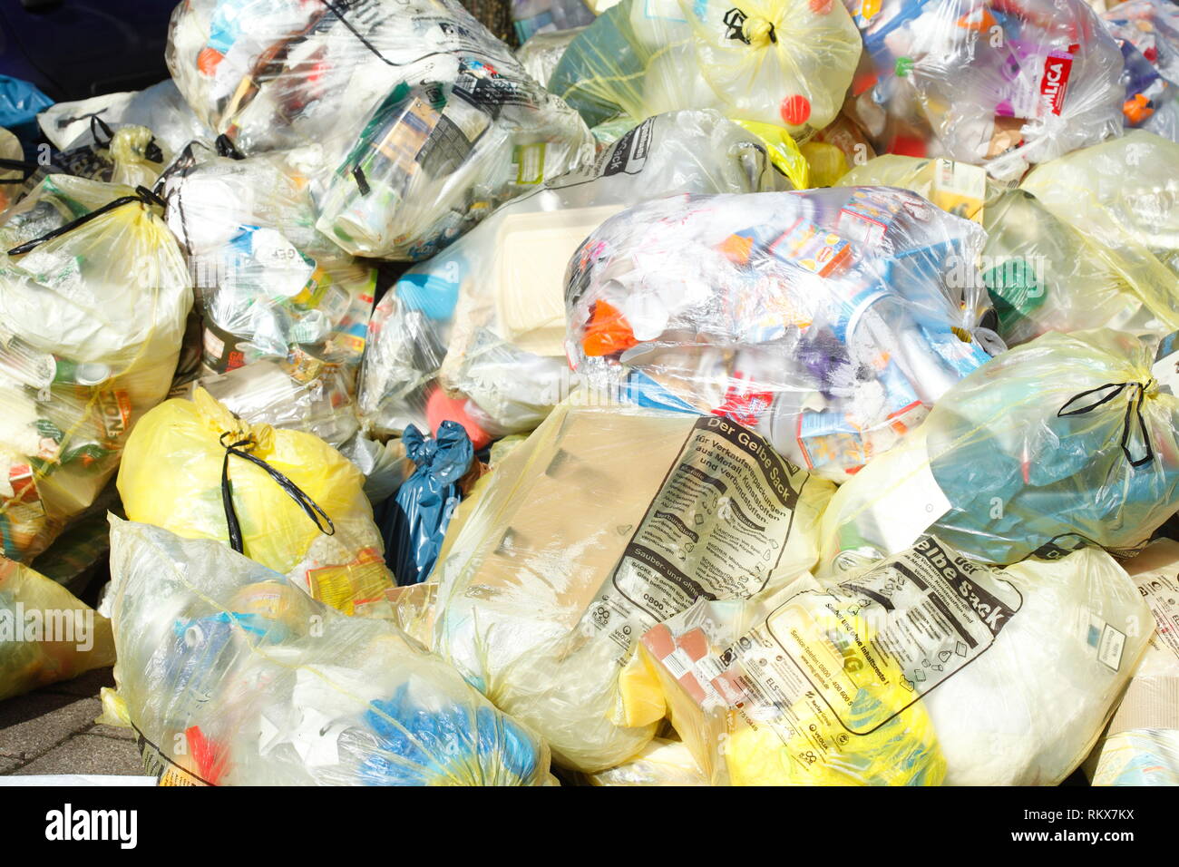 Yellow bags for plastic waste, lying on the curb, Bremen, Germany I Gelbe Säcke für Plastikmüll, auf dem Bordstein liegend, Bremen, Deutschland I Stock Photo