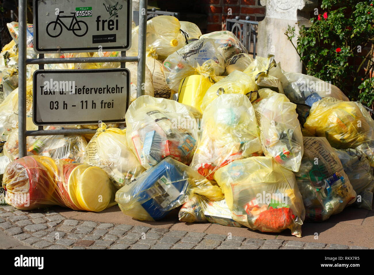 Yellow bags for plastic waste, lying on the curb, Bremen, Germany I Gelbe Säcke für Plastikmüll, auf dem Bordstein liegend, Bremen, Deutschland I Gelb Stock Photo