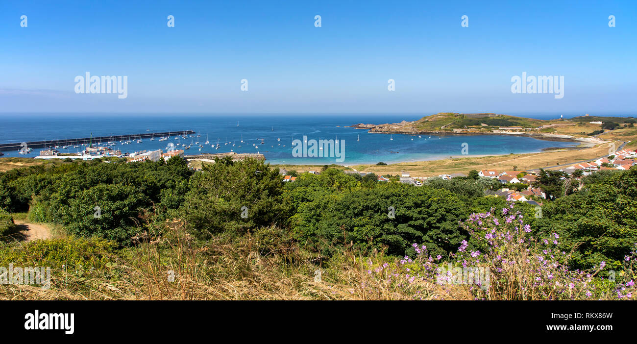 A wide angle panoramic view of Braye harbour and breakwater on Alderney, Channel Islands. Stock Photo