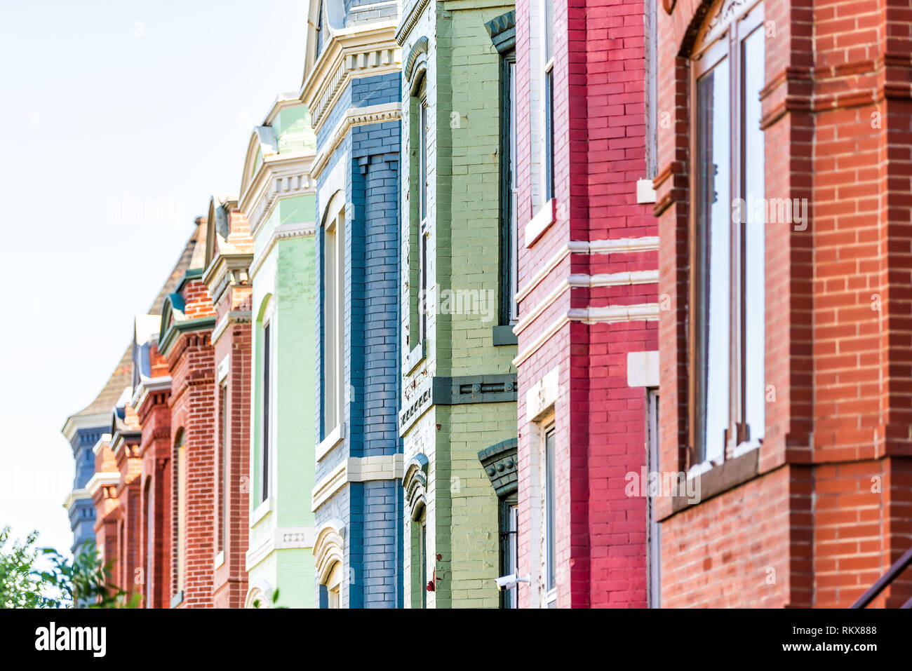 Row of colorful red green and blue painted brick residential townhouses