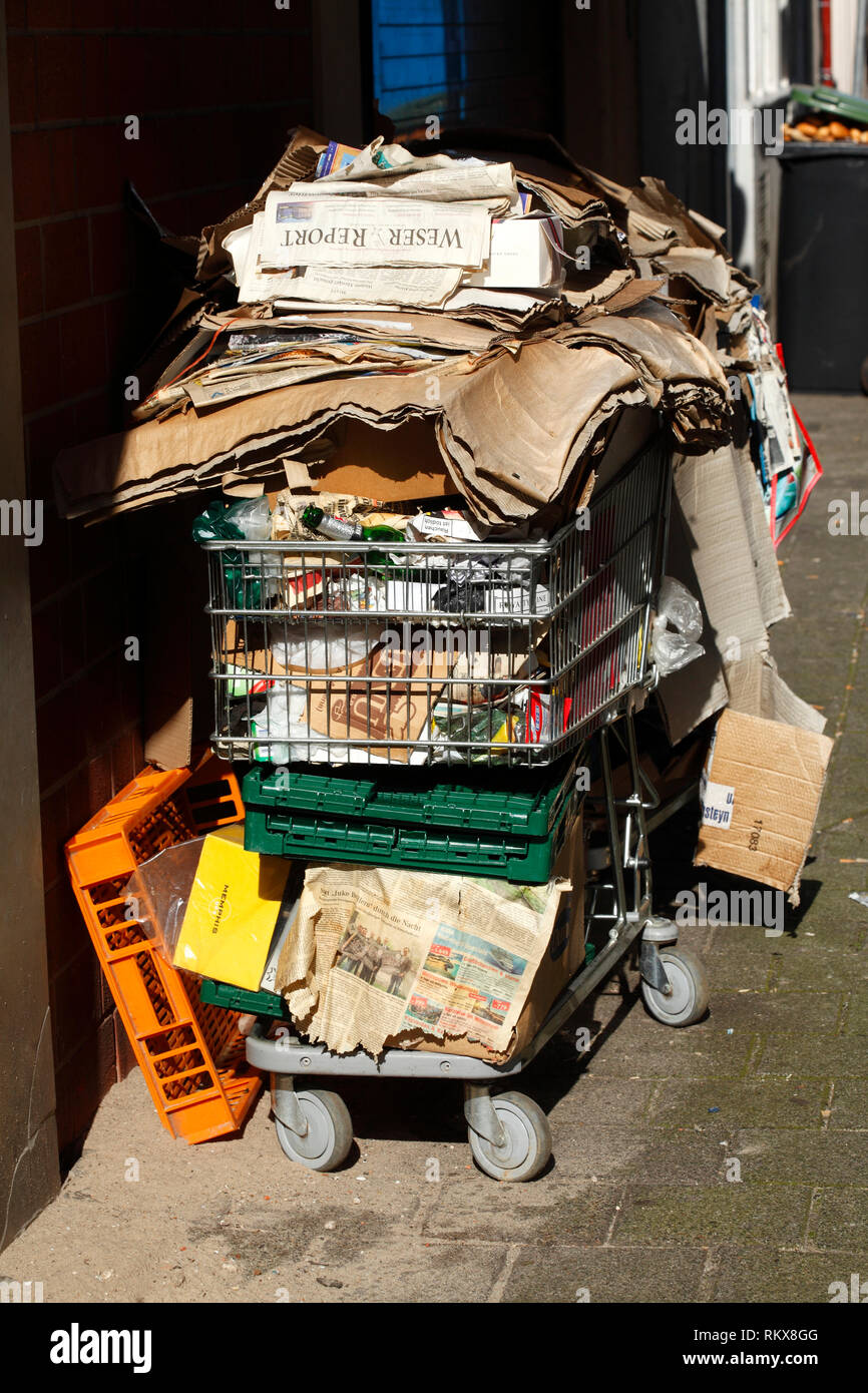 Stacked old paper and old cardboard in a shopping cart, Bremen, Germany I aufgestapeltes Altpapier und Altpappe in einem Einkaufswagen, Bremen, Deutsc Stock Photo