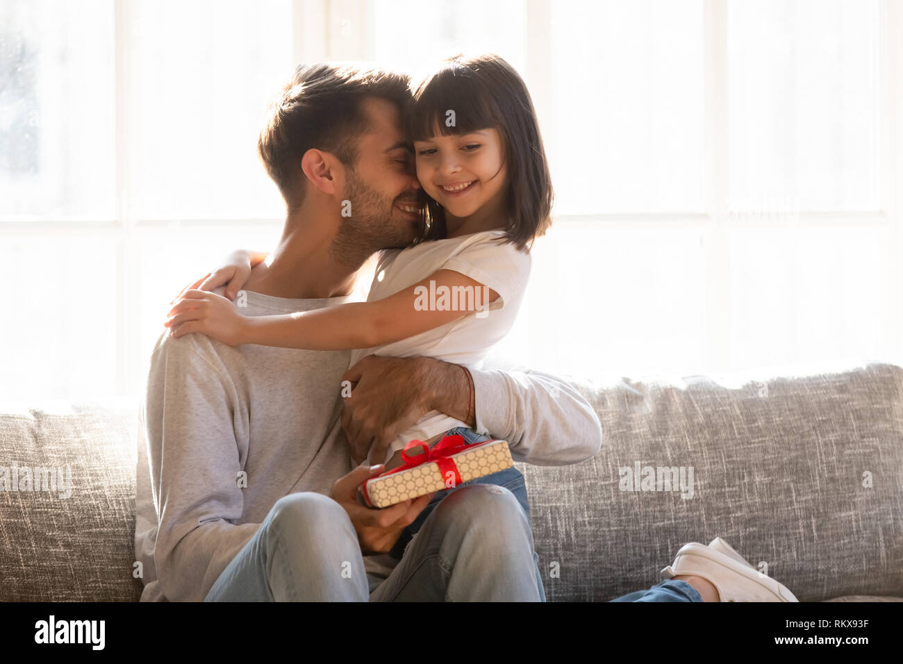 Grateful dad hugging daughter thanking for gift on fathers day Stock Photo 
