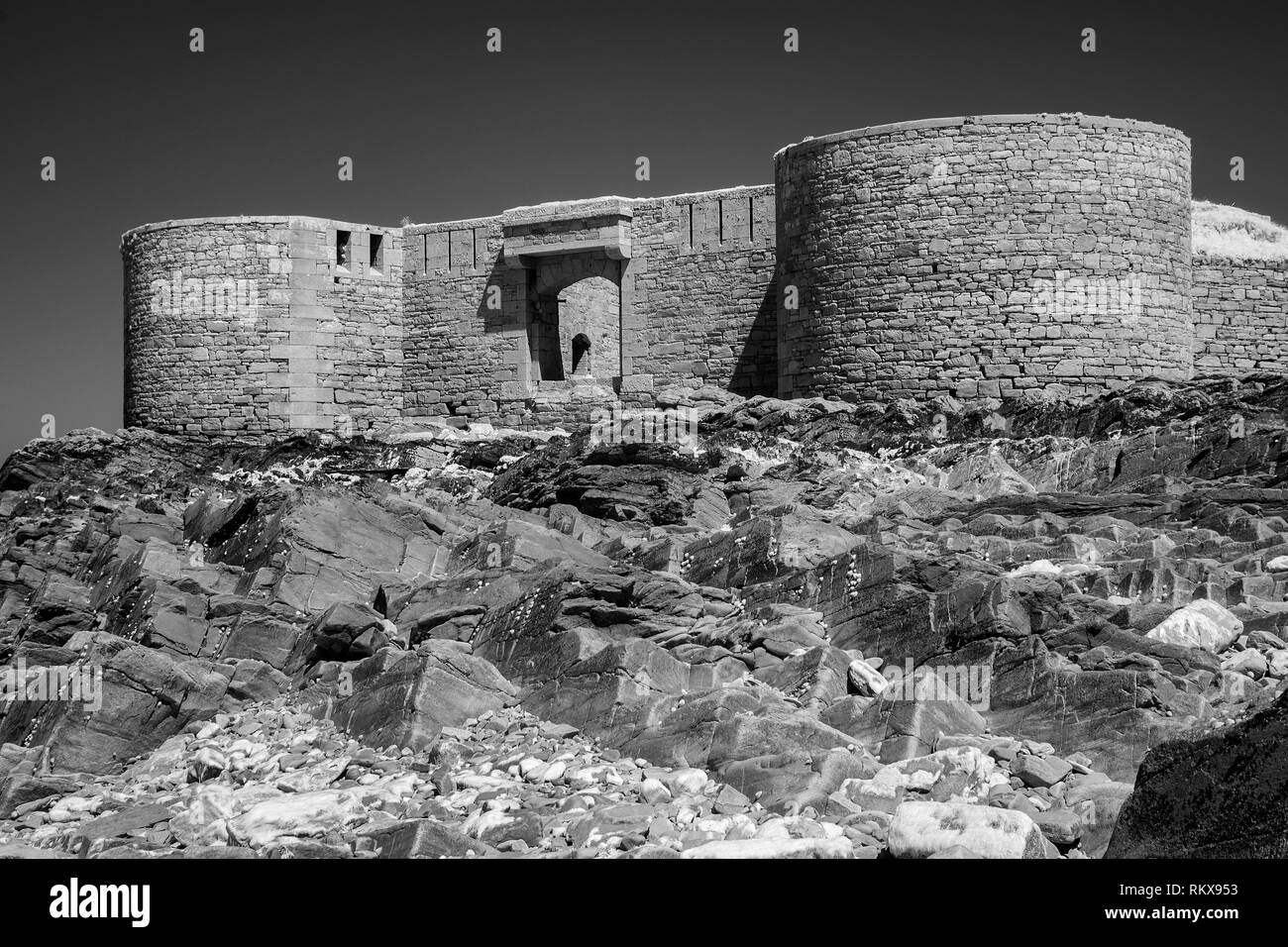 An Infrared monochrome image of Fort Houmet Herbe and causeway on an offshore island on the coast of Aldernney, Channel Islands. Stock Photo