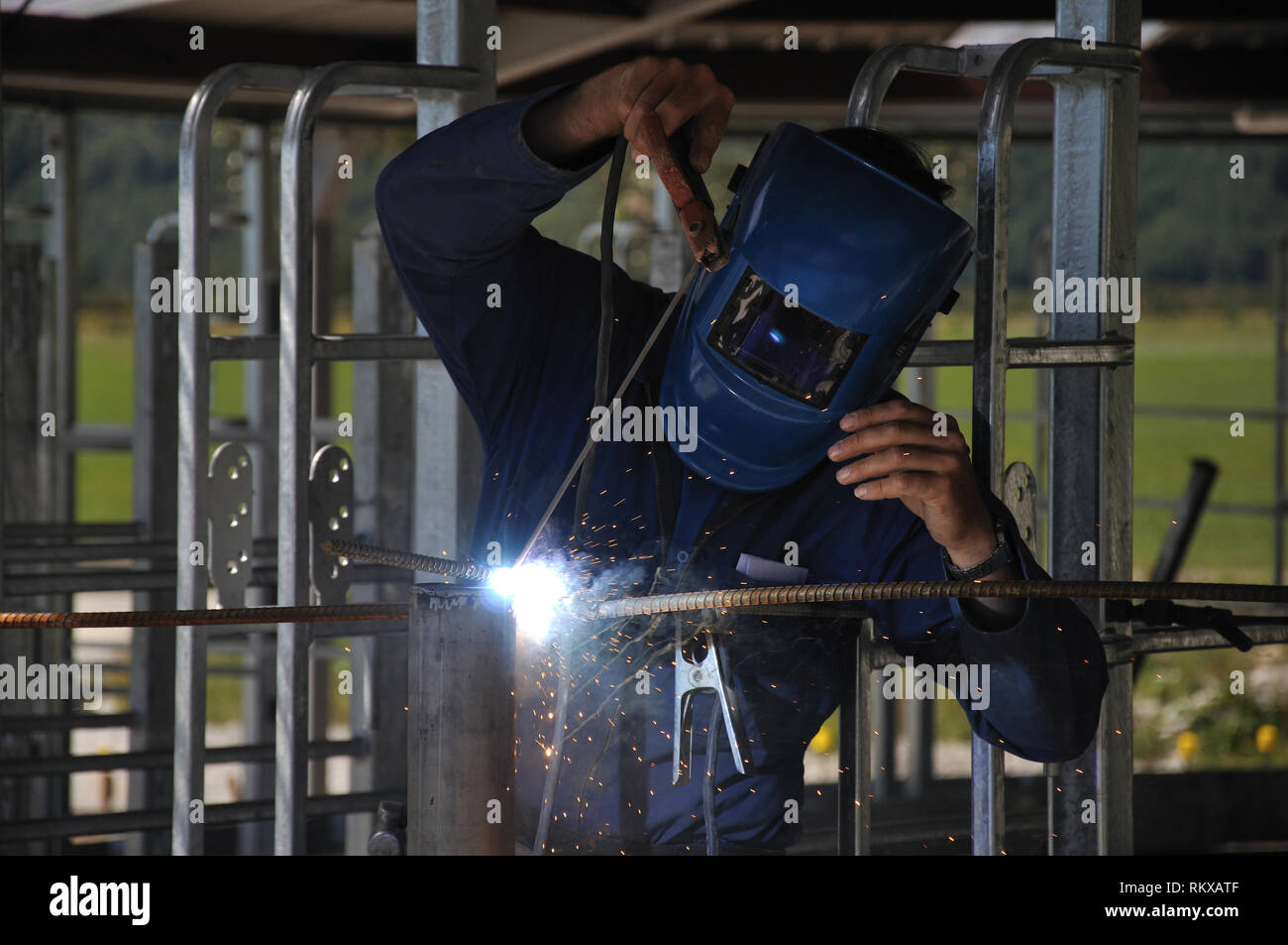 Man spot welding temporary framework in new dairy Stock Photo