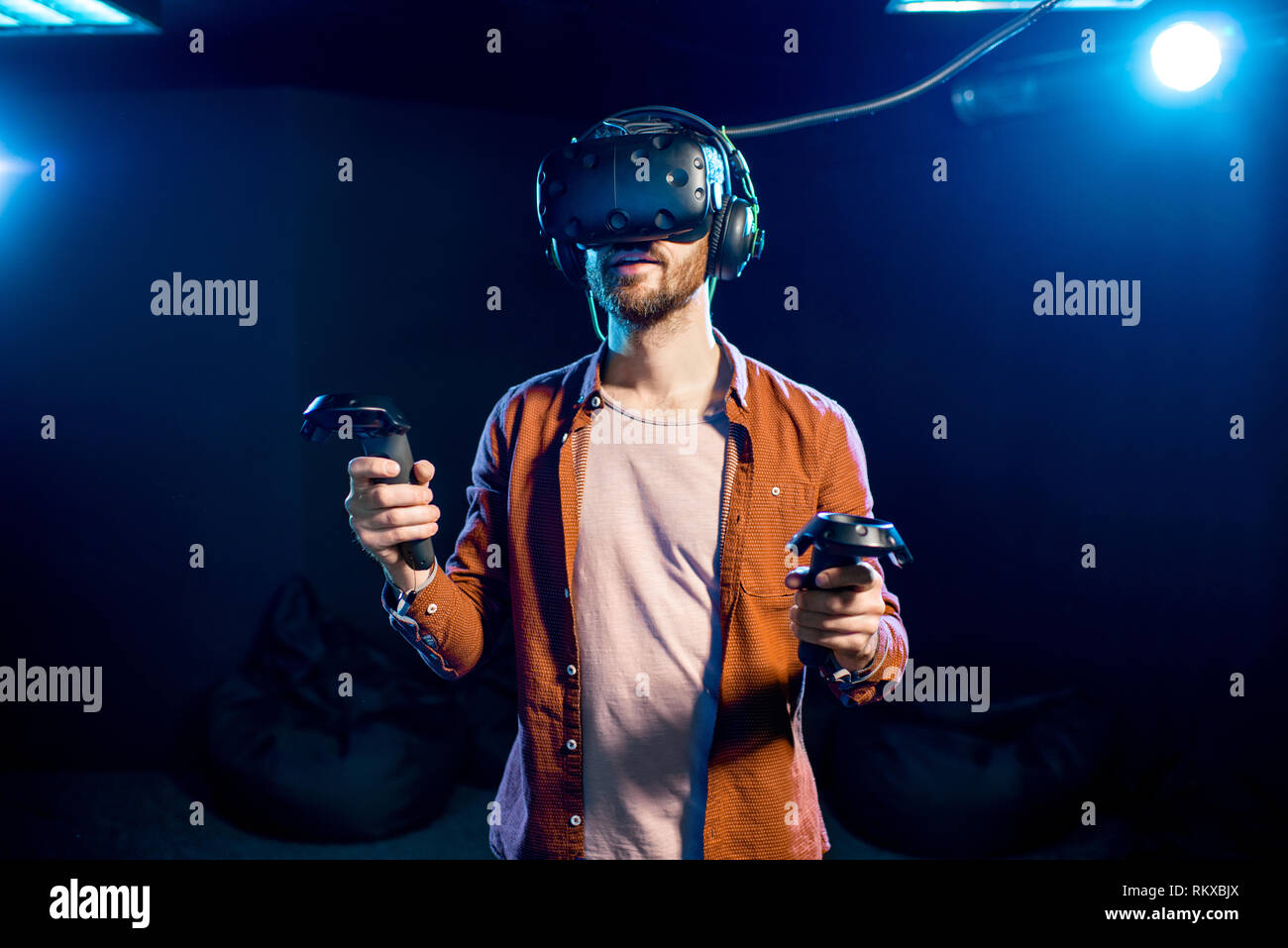 Man Playing Game Using Virtual Reality Headset And Gamepads