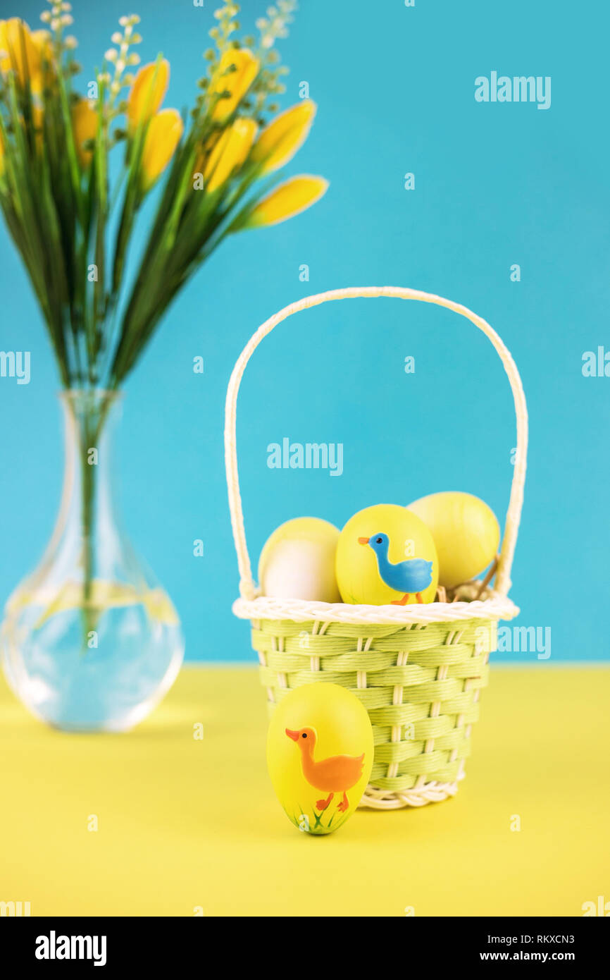 Easter basket with eggs on yellow background. Stock Photo