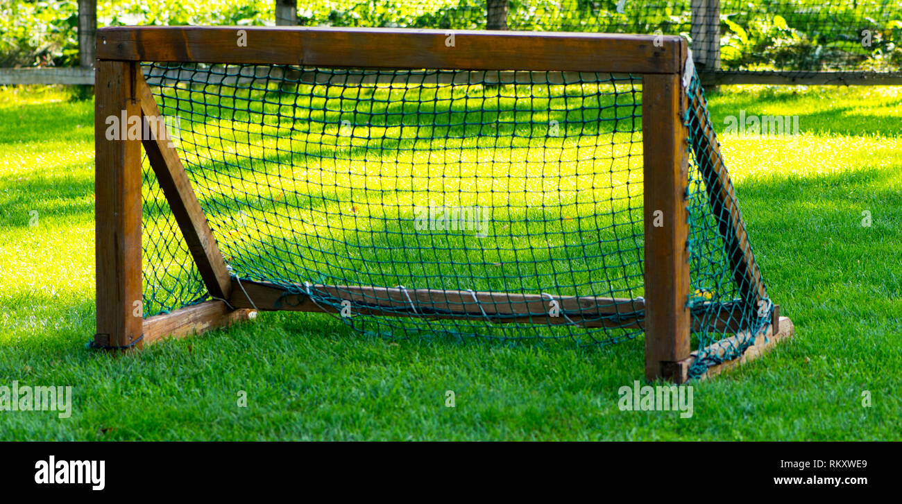 The small wooden goal for the soccer on the empty green field Stock